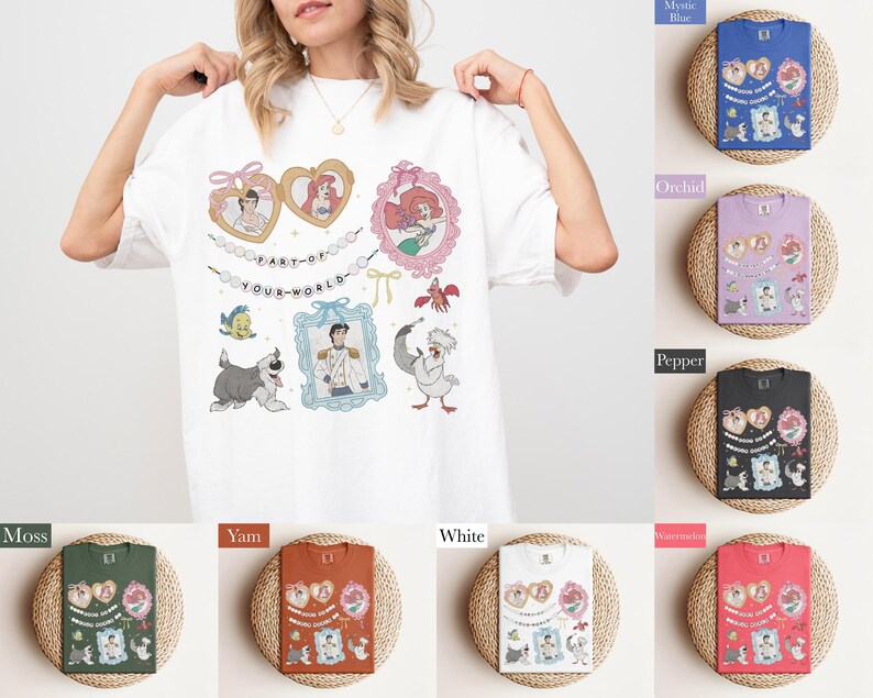 A woman is wearing a white t-shirt with a collage of illustrations and text, including characters from Disney movies and other pop culture references.
