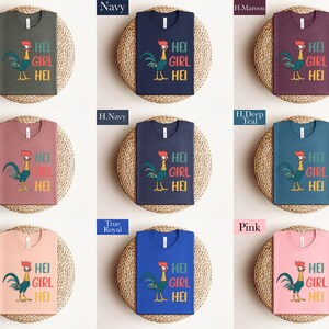 The image is a collage of nine shirts, each with a different color and design, arranged in a 3x3 grid. The shirts feature a cartoon rooster and the text "HEI GIRL HEI" printed on them.
