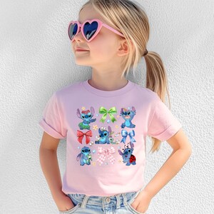 A young girl wearing a pink t-shirt with a graphic of Stitch characters and heart-shaped sunglasses.