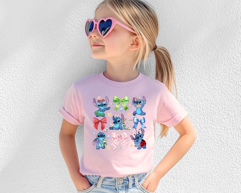 A young girl wearing a pink t-shirt with a graphic of Stitch characters and heart-shaped sunglasses.