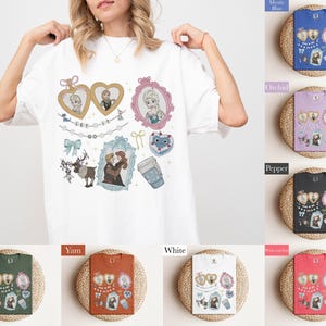 A woman is wearing a white t-shirt with various cartoon characters and illustrations on it, including a heart, a cup, and other whimsical designs.