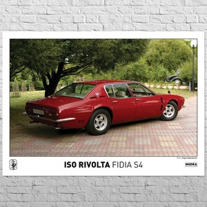 May include: A red ISO Rivolta Fidia S4 sports car parked on a brick driveway. The car is surrounded by green trees and bushes.
