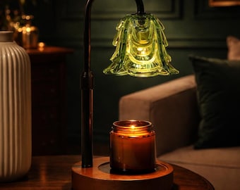 May include: A decorative table lamp with a green glass shade shaped like a flower. The lamp has a black metal frame and sits on a wooden base. A lit candle in a glass jar is on the base, creating a warm ambiance.