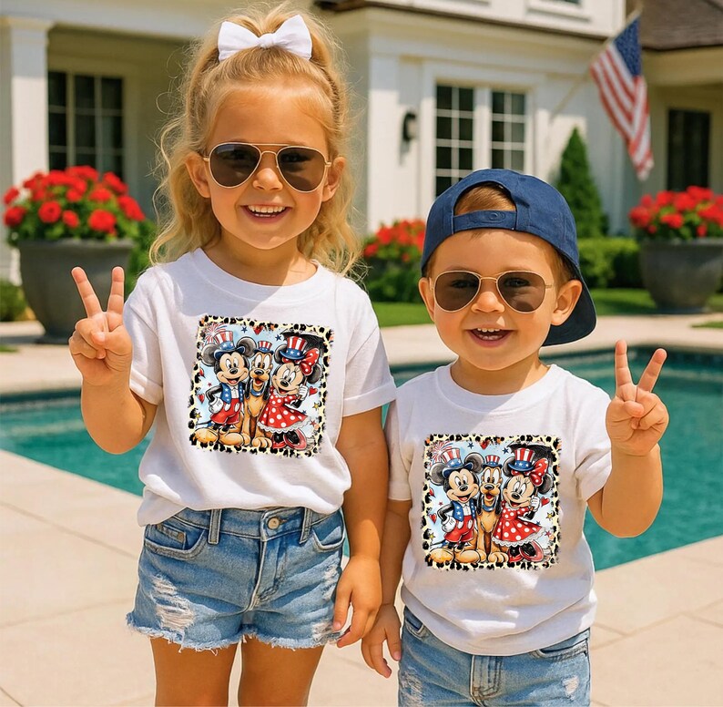Two children wearing sunglasses and patriotic-themed t-shirts are standing in front of a house with a pool and an American flag.
