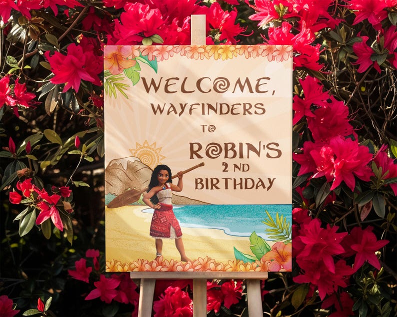 May include: A wooden sign with the words "WELCOME, WAYFINDERS TO ROBIN'S 2ND BIRTHDAY" in brown lettering. The sign features a cartoon illustration of a girl on a beach with a mountain and sun in the background. The sign is displayed on a white easel.