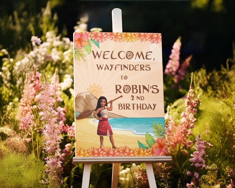 May include: A welcome sign on an easel, featuring a cartoon illustration of a character on a beach. The sign reads "Welcome, Wayfinders to Robin's 2nd Birthday" with floral and tropical design elements. The sign is surrounded by greenery and flowers.
