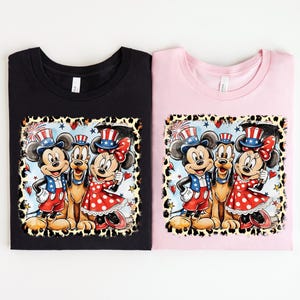 two t-shirts with a cartoon-style illustration of Mickey Mouse and Minnie Mouse, along with other Disney characters, on a leopard print background.