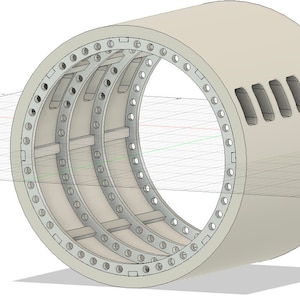 Puede incluir: Estructura cilíndrica renderizada en 3D, de color gris claro. El diseño presenta múltiples soportes internos y una serie de agujeros espaciados uniformemente alrededor del borde exterior. Se ven cortes rectangulares en el lateral.