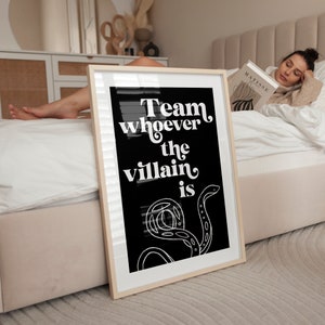 Puede incluir: Impresi&oacute;n enmarcada en blanco y negro con el texto "Team whoever the villain is" y un dise&ntilde;o de serpiente estilizado.