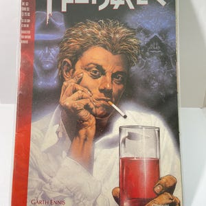 May include: A comic book cover featuring a man with blond hair smoking a cigarette and holding a glass of red liquid. The cover is for Hellblazer #63, featuring John Constantine. The text on the cover reads "DC Vertigo", "Hellblazer", "Garth Ennis", "Steve Dillon", and "GFABRY 92".