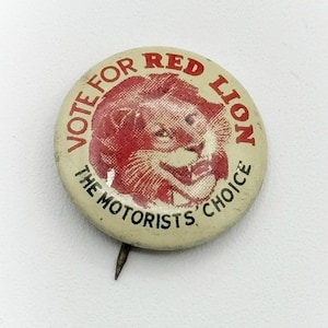 May include: A white button with a red lion head and the text "Vote for Red Lion The Motorists' Choice".