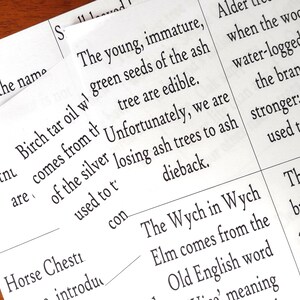 May include: Close-up of a page from a book about trees. The text describes the characteristics of ash trees, including their young, immature green seeds, and the fact that they are edible. The text also mentions that ash trees are susceptible to dieback.