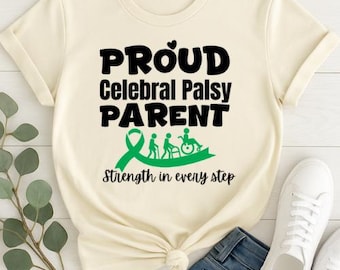 May include: Cream-colored t-shirt with the text "PROUD Cerebral Palsy PARENT" in black. A green ribbon and figures of people in a wheelchair and walking are below the text. The phrase "Strength in every step" is written below the figures.