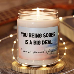 May include: A white candle with a pink and blue ombre design and the text "You being sober is a big deal. I am so proud of you."
