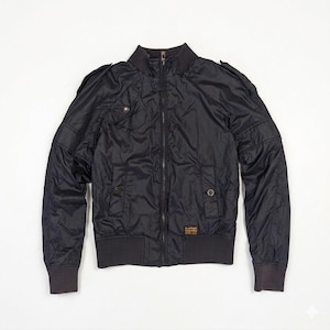 May include: A black bomber jacket with a ribbed collar, cuffs, and hem. The jacket features a zip-up front, two front pockets, and shoulder epaulettes. A small label is visible on the lower right side. The jacket is made of a shiny, quilted material.