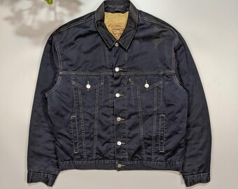 May include: A black denim jacket with a button closure and two front pockets. The jacket has a Levi's label on the pocket.