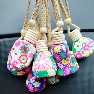 May include: A group of colorful, floral patterned car air fresheners with wooden tops and string hangers.