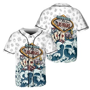 May include: White baseball jersey with a "Welcome to Fabulous Las Vegas Nevada" sign graphic. The design includes playing cards, dice, and ocean waves. The jersey has a button-up front and black trim.