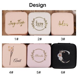K&ouml;nnte beinhalten: Sechs verschiedene Designs f&uuml;r eine kleine, quadratische Schmuckschatulle. Die Schachteln sind rosa, wei&szlig; und schwarz mit goldenen Schriftz&uuml;gen und Designs. Die Designs beinhalten Namen, Blumenmuster und Kr&auml;nze. Die Schachteln sind von 1 bis 6 nummeriert.