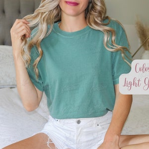 May include: A light green t-shirt with short sleeves. The text "Color Light Green" is displayed in a decorative font. The shirt is made of a soft material and is a solid color.