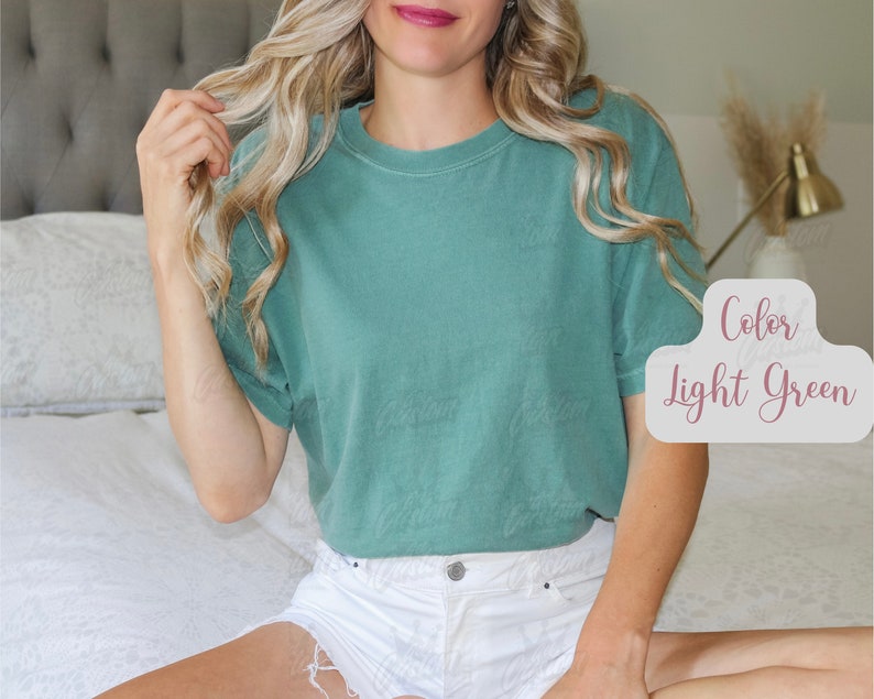 May include: A light green t-shirt with short sleeves. The text "Color Light Green" is displayed in a decorative font. The shirt is made of a soft material and is a solid color.