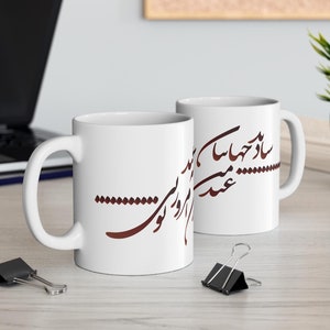 May include: Two white ceramic mugs with a brown calligraphy design. The design on the mug on the left says "تو را دوست دارم" and the design on the mug on the right says "عشق تو مرا دیوانه می کند".