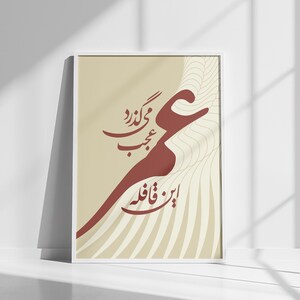May include: A framed art print featuring calligraphy in shades of burgundy and brown against a beige background. The artwork is displayed in a white frame and leans against a white wall. The text is in a stylized script.