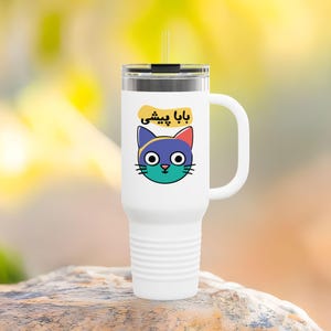 May include: White stainless steel travel mug with a black lid and a handle. The mug has a colorful cartoon cat with the text "Baba Yeshi" in Arabic script.