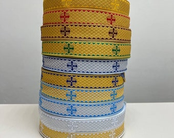 Puede incluir: Una pila de ocho cintas de adorno doradas, blancas, azules, verdes, rojas y burdeos con un patrón de cruz.