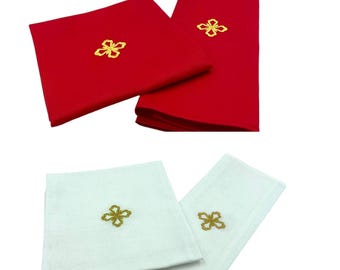 Könnte beinhalten: Zwei Sätze Altardecken, eine rote und eine weiße, jede mit einem goldenen gestickten Blumendesign.