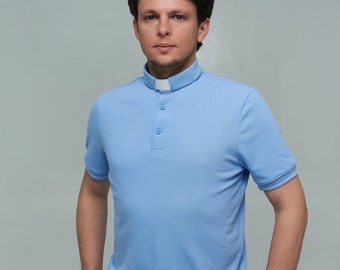 May include: A light blue collared shirt with a white collar and three buttons. The shirt has short sleeves and is made of a soft, comfortable fabric.