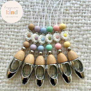 May include: Seven pastel-colored silicone beaded car air fresheners with daisy charms and wooden diffuser bottles. The beads are in shades of pink, blue, green, and yellow. The diffuser bottles are silver and wood.