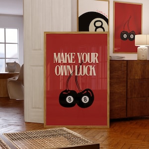 Könnte beinhalten: Ein roter Poster mit dem Text "Make Your Own Luck" in weißen Buchstaben. Zwei schwarze Kirschen mit der Nummer "8" darauf sind auf dem Poster.