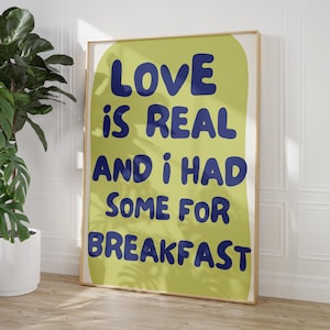 Può includere: Un poster giallo con un testo blu sovrapposto che dice "LOVE is REAL and i had some for BREAKFAST".