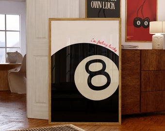 May include: A framed art print featuring a black and white eight ball design with the text "i'm feeling lucky" in red. Two other framed prints are visible, one with cherries and the other with the text "MAKE YOUR OWN LUCK".