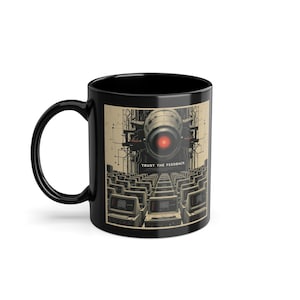 Op de afbeelding: Zwarte keramische mok met een afbeelding van een robot met rode ogen en de tekst "TRUST THE FEEDBACK" eronder gedrukt. De robot wordt omringd door rijen computermonitoren.