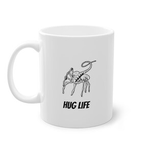 Tazza Alien Facehugger "Hug Life" / Divertente tazza da caffè fantascientifica / Design alieno unico / Regalo perfetto per i fan della fantascienza / Tazza in ceramica bianca da 11 once