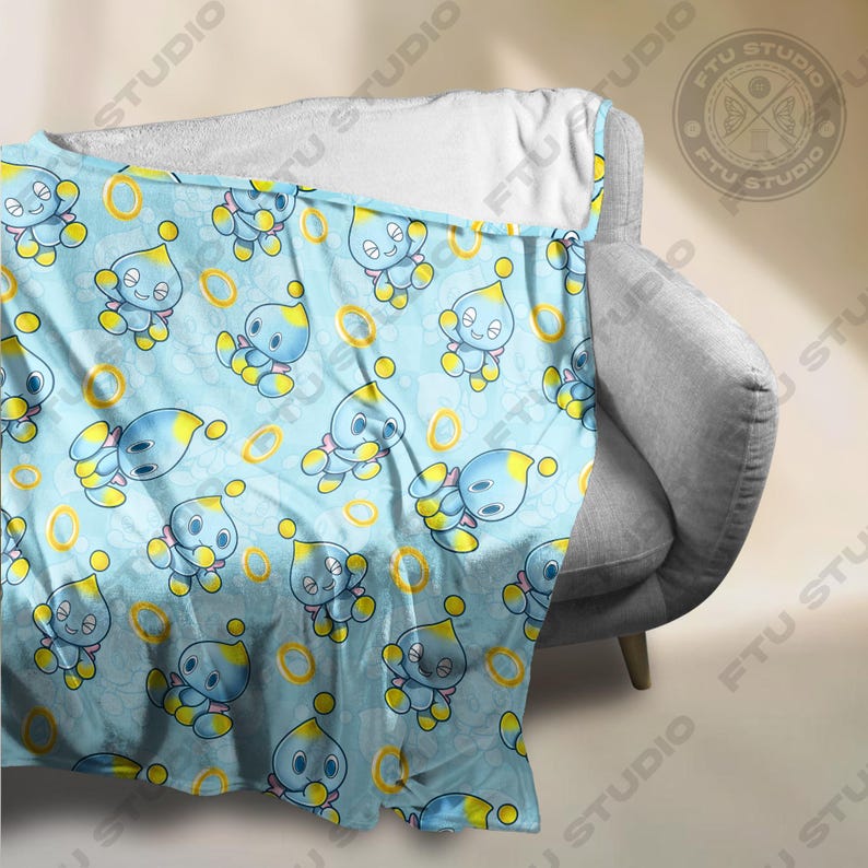 May include: A blue and yellow fleece blanket with a repeating pattern of a blue character with yellow accents and gold rings.