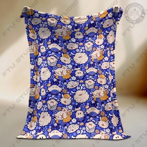 May include: A blue blanket featuring a repeating pattern of cartoon characters, flowers, and leaves. The characters are in various poses and colours, including white, orange, and grey. The blanket is made of a soft material.