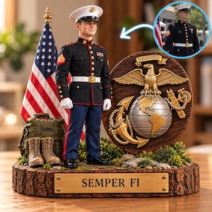 May include: A figurine of a United States Marine in dress blues with a white cap, standing beside an American flag, a green USMC duffel bag, and tan boots. A circular plaque features the Eagle, Globe, and Anchor emblem with the text Semper Fidelis.