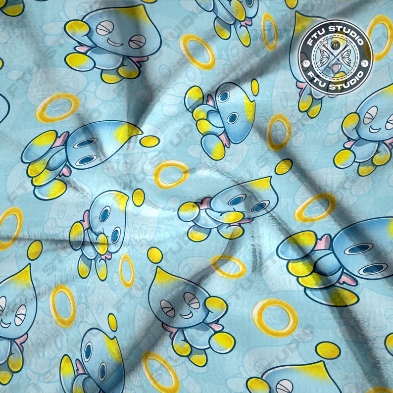 May include: A blue and yellow fabric with a repeating pattern of a blue cartoon character with yellow accents. The character is holding a yellow ring. The fabric also has a repeating pattern of yellow rings. The fabric has the text "FTU STUDIO" in a circle.