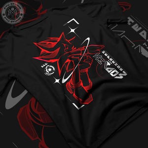 Könnte beinhalten: Schwarzes T-Shirt mit einer roten und weißen Grafik von Shadow the Hedgehog aus dem Videospiel "Sonic the Hedgehog". Die Grafik zeigt Shadow in einer dynamischen Pose mit einem weißen Stern und einer weißen Umlaufbahn um ihn herum. Der Text "SHADOW THE HEDGEHOG" ist in weißen Buchstaben unter der Grafik geschrieben.