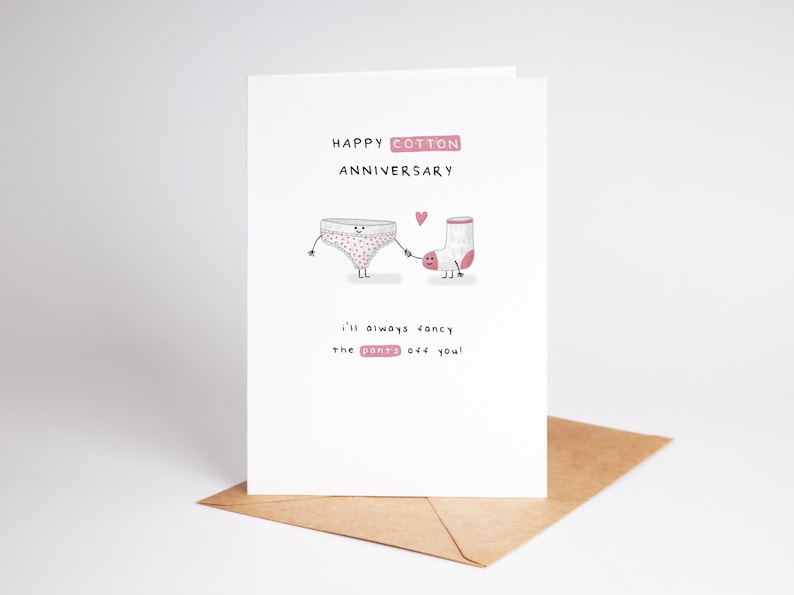 May include: A white card with pink lettering that says "Happy Cotton Anniversary".  The card features a cartoon illustration of a pair of underwear and a sock holding hands.  The text below the illustration says "I'll always fancy the pants off you!"