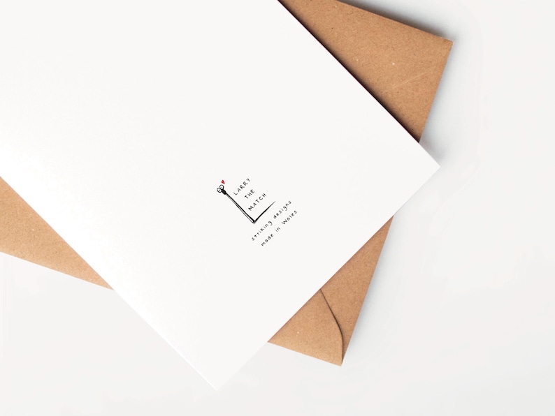 May include: A white card with a black and white illustration of a matchstick with the text "Larry the Match" and "Striking designs made in Wales".