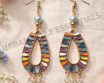 May include: A pair of gold-tone drop earrings featuring a teardrop-shaped frame filled with multicolored enamel petals in orange, yellow, blue, purple, and white. Each earring includes a light blue pearl bead and three small clear crystal dangles.