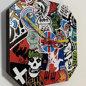 May include: A black octagonal clock with a red, white, and blue Union Jack design. The clock face is covered in colourful stickers with punk rock themes, including the words "Dead End! 666", "Punk Rock", "Misfits", and "100% Tears My Enemies".