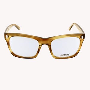 Può includere: Un paio di occhiali con montatura marrone chiaro, tartarugata. Le lenti rettangolari sono trasparenti. Il marchio "MOSCOT ORIGINALS" è stampato sulla lente inferiore destra.