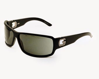 Może przedstawiać: Czarne okulary przeciwsłoneczne z prostokątną oprawą i ciemnymi soczewkami. Logo Gucci jest widoczne na zausznikach. Okulary przeciwsłoneczne mają sportowy design i nadają się do aktywności na świeżym powietrzu.