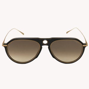 Puede incluir: Gafas de sol aviador negras con montura dorada y lentes degradadas. Las gafas tienen una forma única con puente y varillas finas. Las lentes hacen una transición de marrón claro a un tono más oscuro.