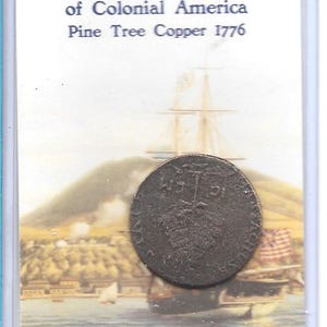 May include: A copper coin from Colonial America, featuring a pine tree design. The coin is displayed in a protective sleeve, with the text "Massachusetts Coinage of Colonial America Pine Tree Copper 1776". The background shows a harbor scene.